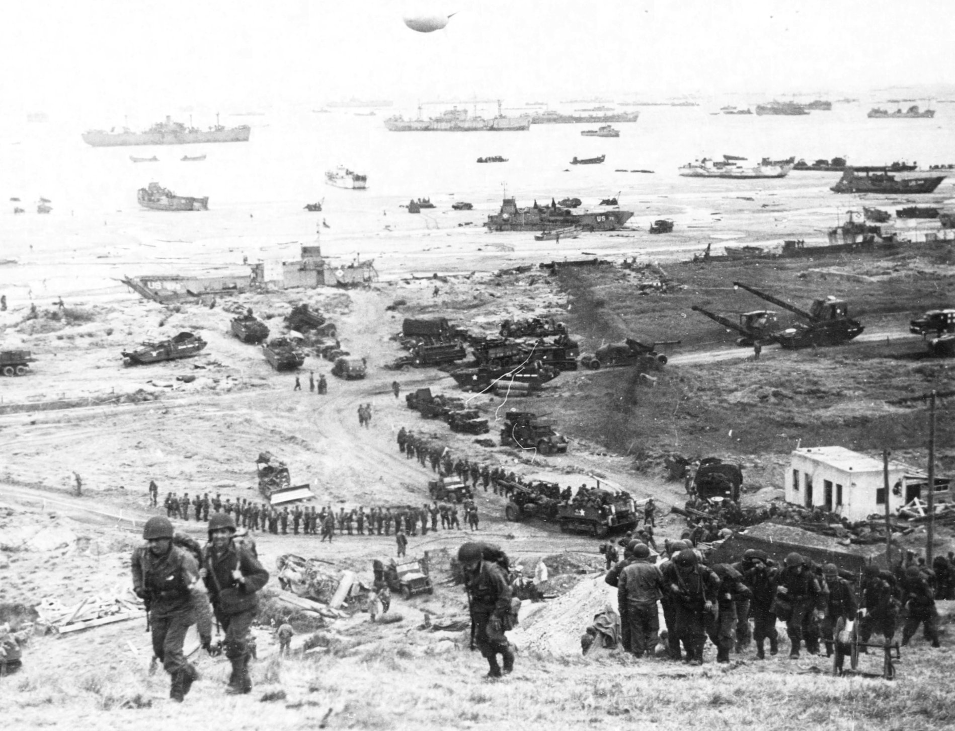 Reinforcements of men and equipment moving inland at Omaha Beach